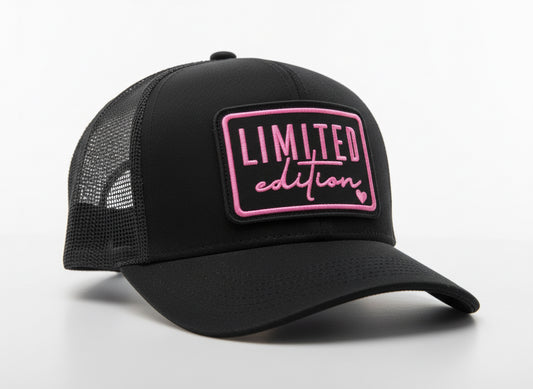 Black mannequin heads with pink 'Limited edition' signs in a store window.